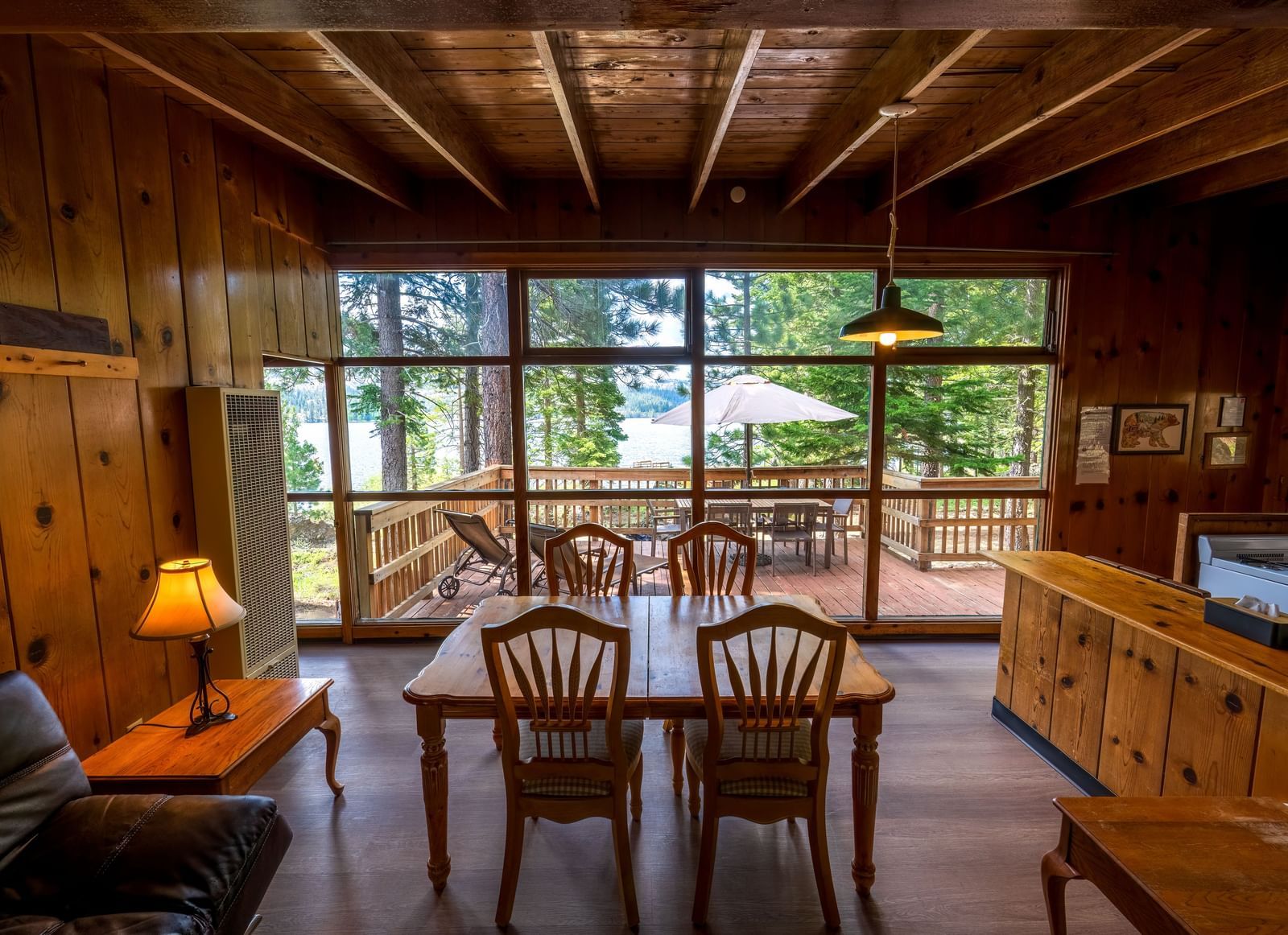 Cabin dining area with large windows offering forest views at Kit Carson Lodge.