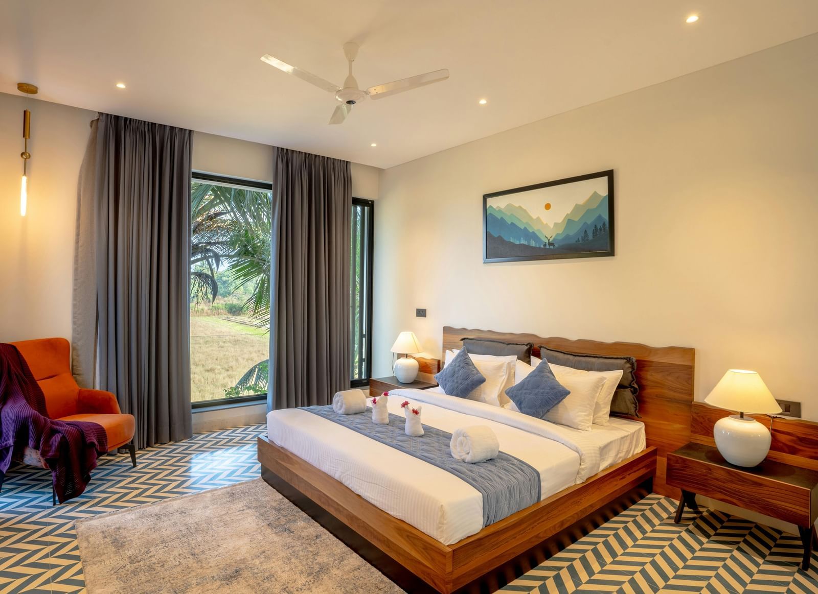A cosy room featuring a neatly made bed, matching side tables, a large window that fills the space with natural light, and contemporary furnishings