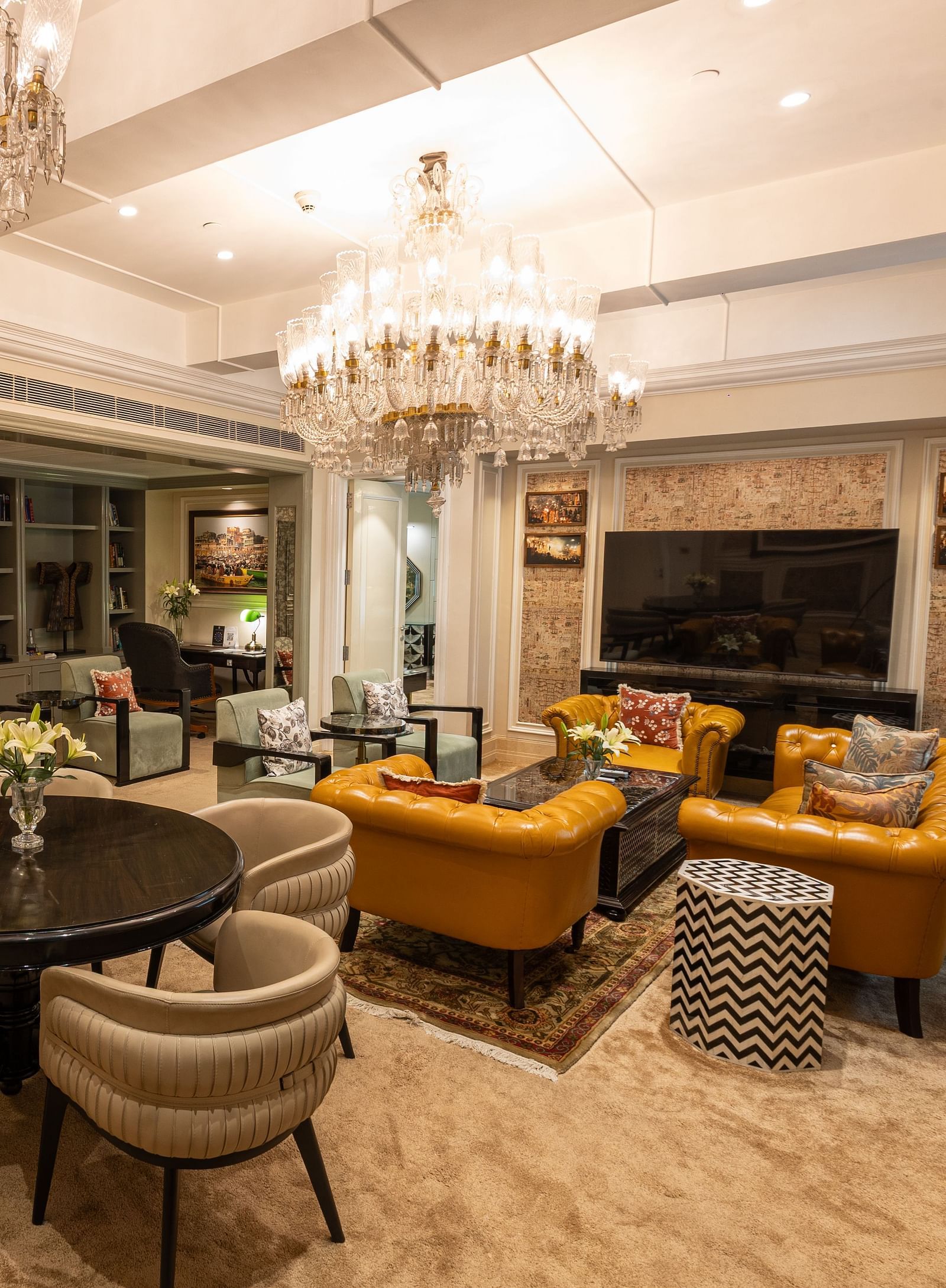 Presidential Suite at The Claridges New Delhi, featuring a spacious area with a cosy couch and a chandelier hanging overhead