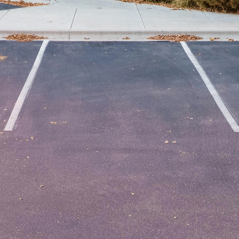 A modern 2-storey office building with large windows and wooden accents, set against a blue sky at dusk or sunset.