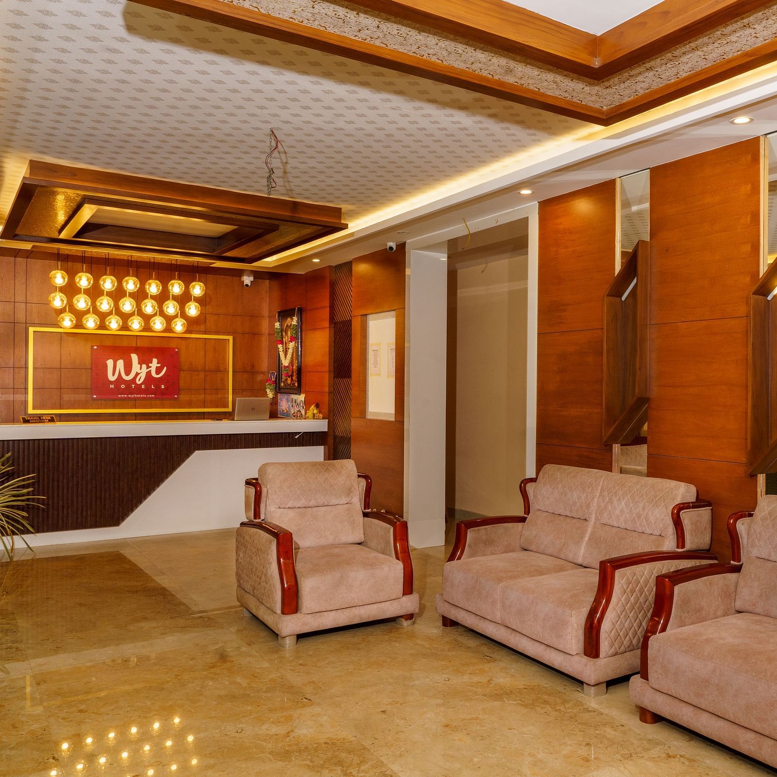 Lobby area with sofas and wooden wall panel at Wyt Hotels, Rameswaram