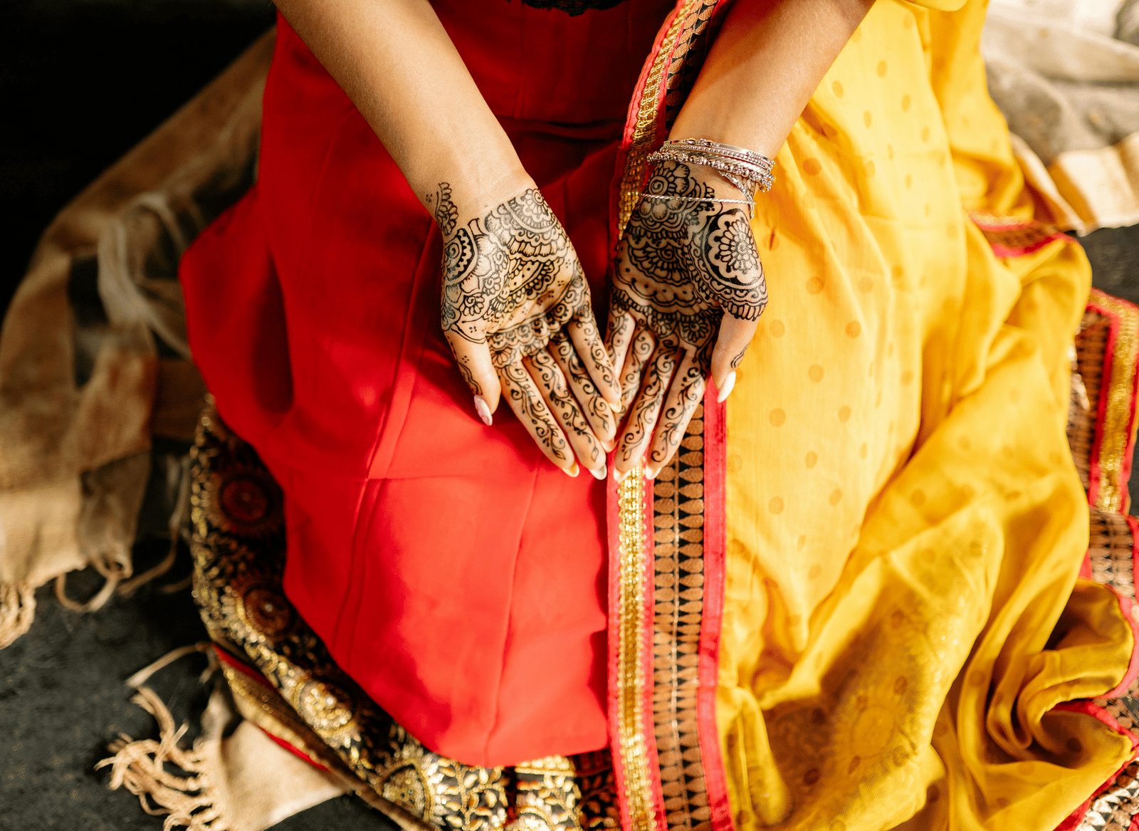 A woman with her palms open showing her mehendi on her hands.