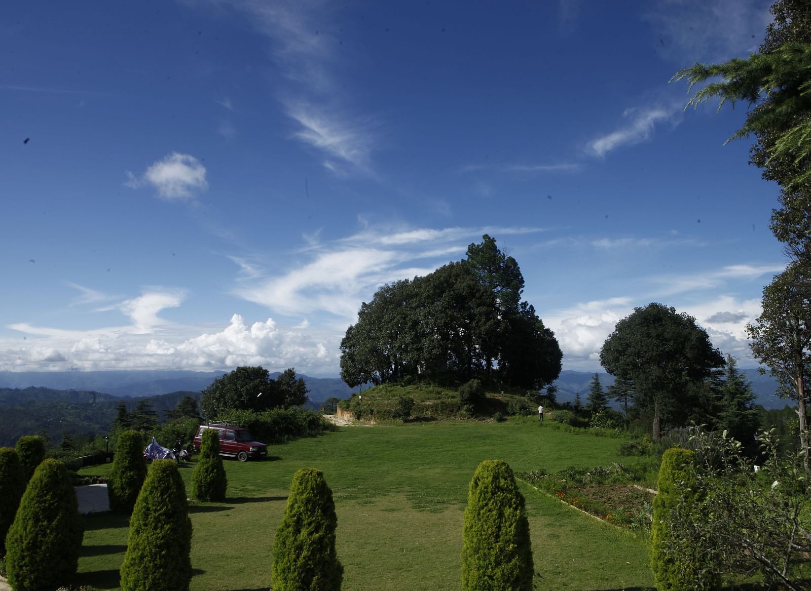 A vibrant wedding lawn in Almora with a scenic backdrop of hills and trees - BluSalzz Escapade - Anant Rasa Resort
