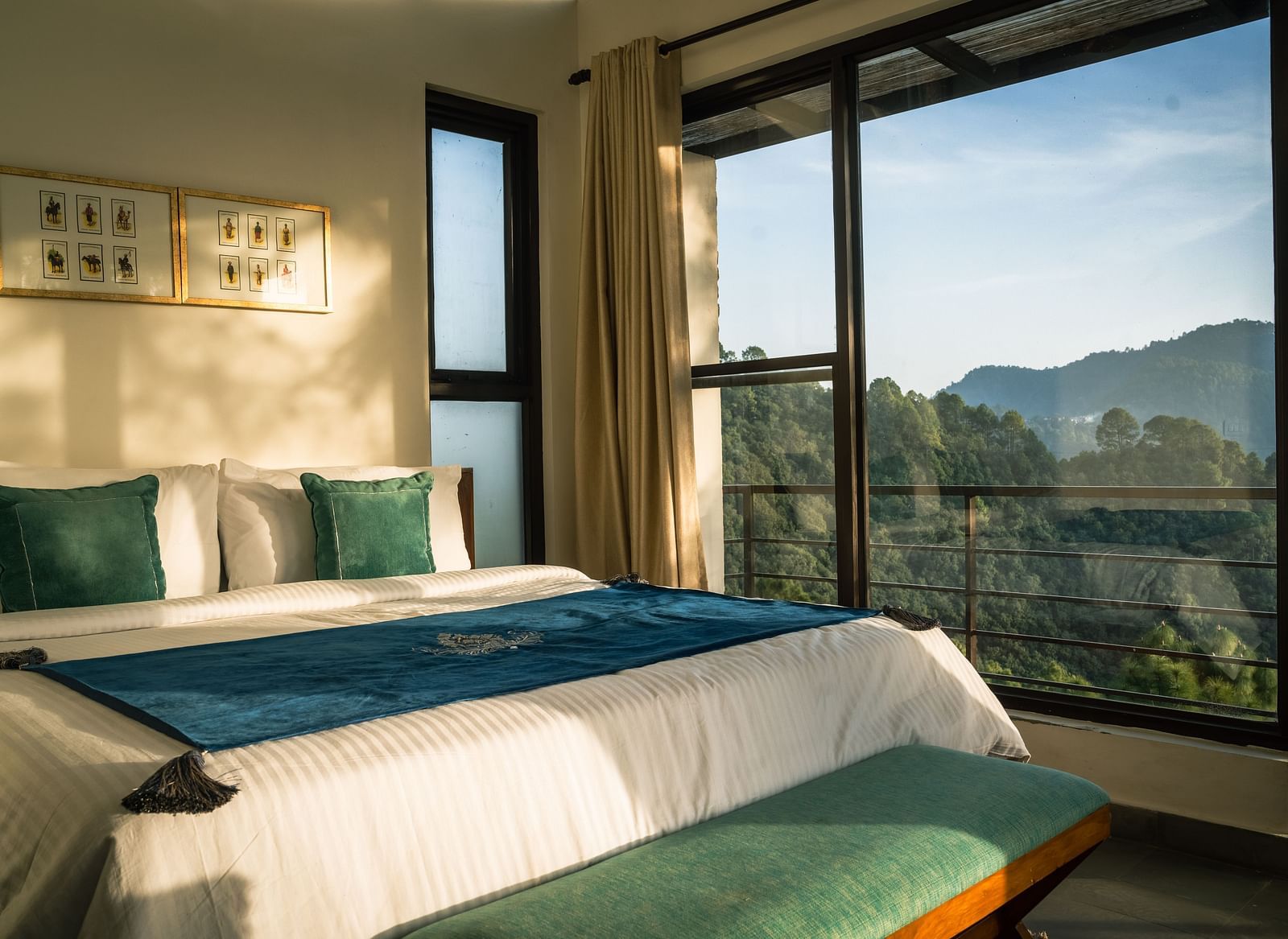 A bedroom with a balcony offering a mountain view and sunlight streaming in at BluSalzz Escapade Resort, Lansdowne