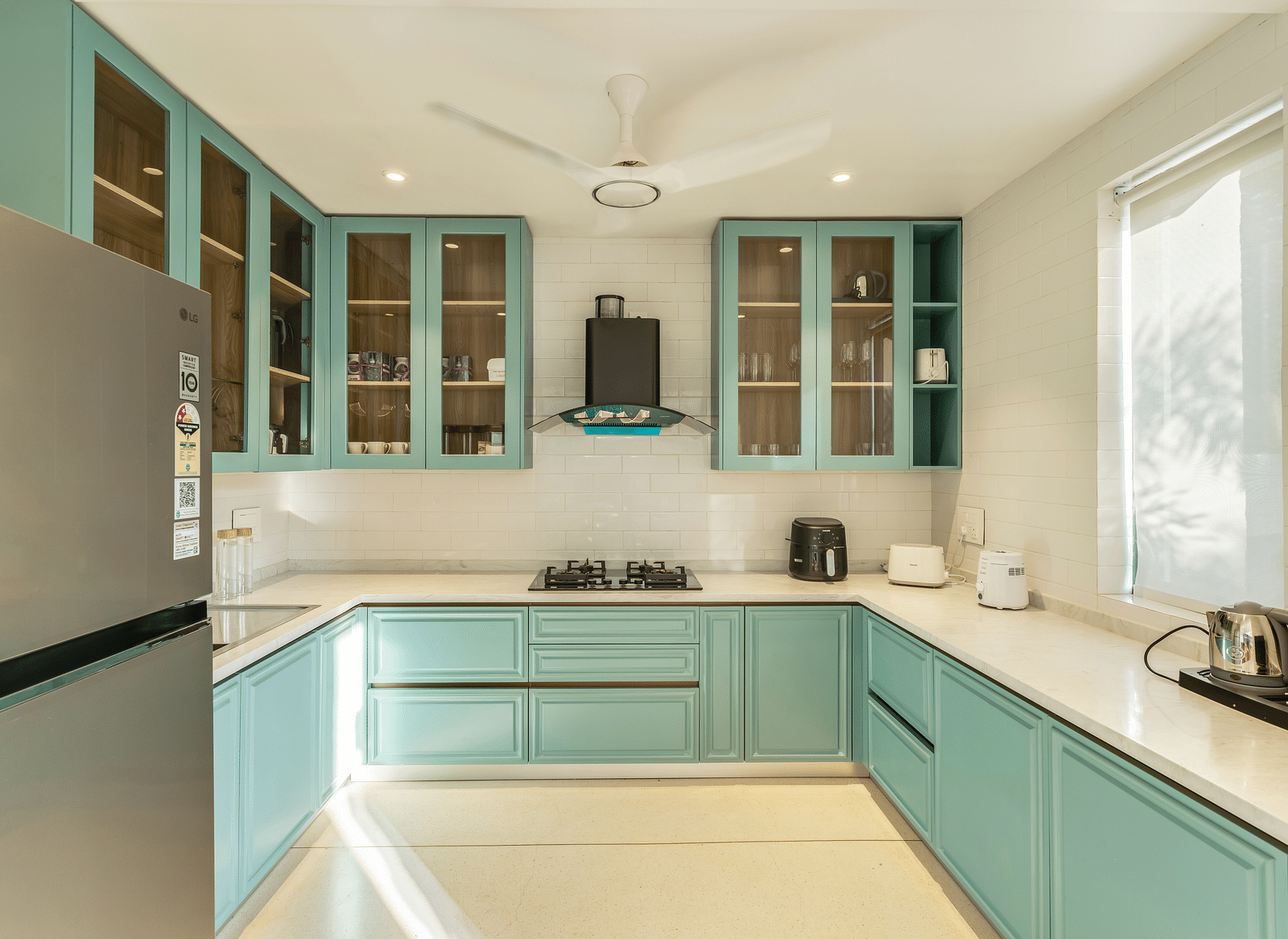A contemporary kitchen with pastel blue cabinets, integrated appliances, and ample natural light creating an airy and functional space - BluSalzz Villas - Alocassia, Anjuna