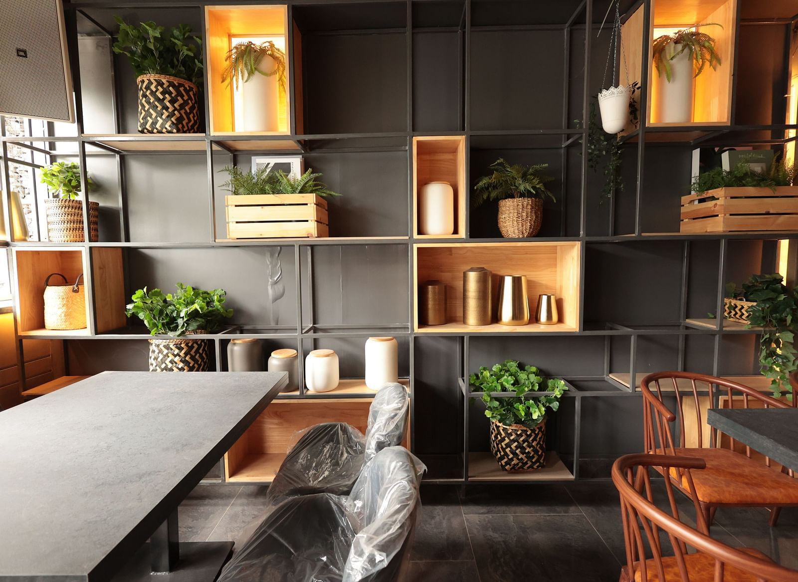 A spacious dining area with a background shelf decorated with plants, pots, and vessels | Cenneys Gateway