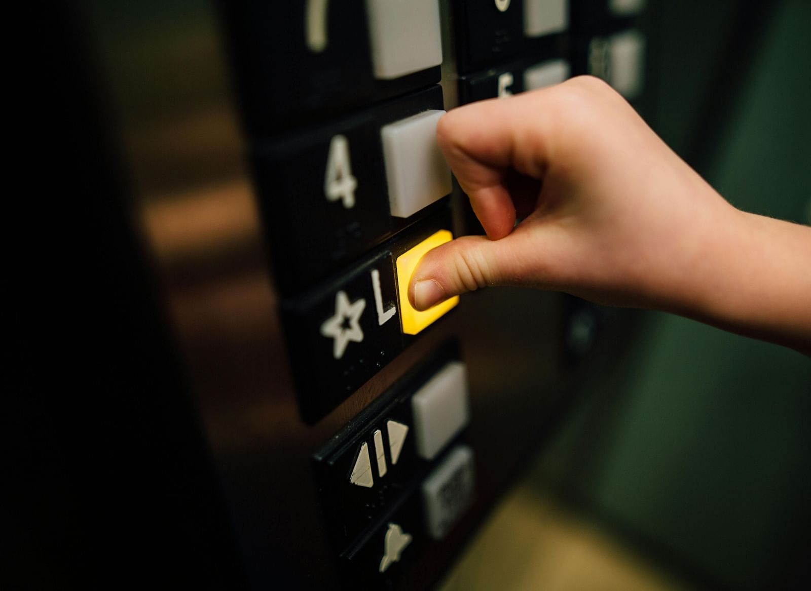 A person pressing on a button in the lift.
