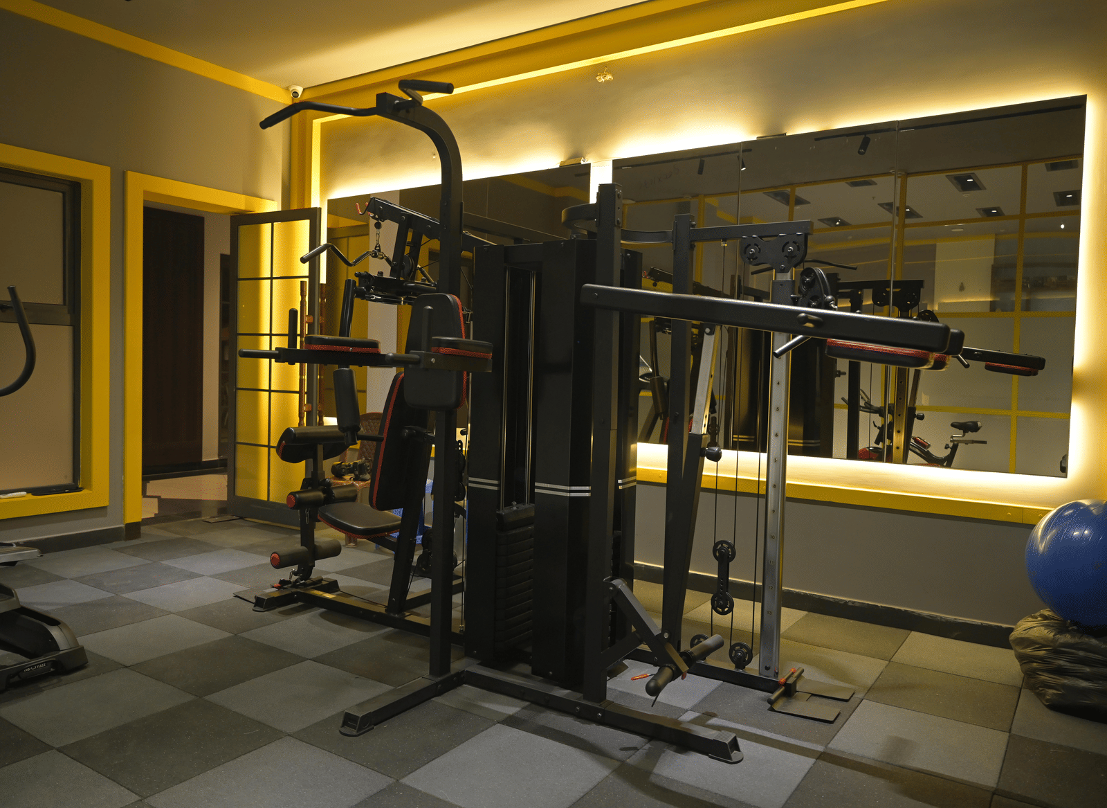Multi-functional workout station with mirrors and warm lighting at Hotel Sonar Bangla Mayapur.