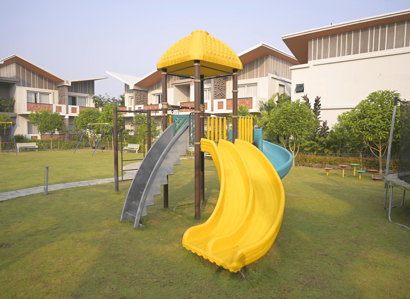 A spiral slide and climbing structure in the outdoor play area at Hotel Sonar Bangla Mayapur.