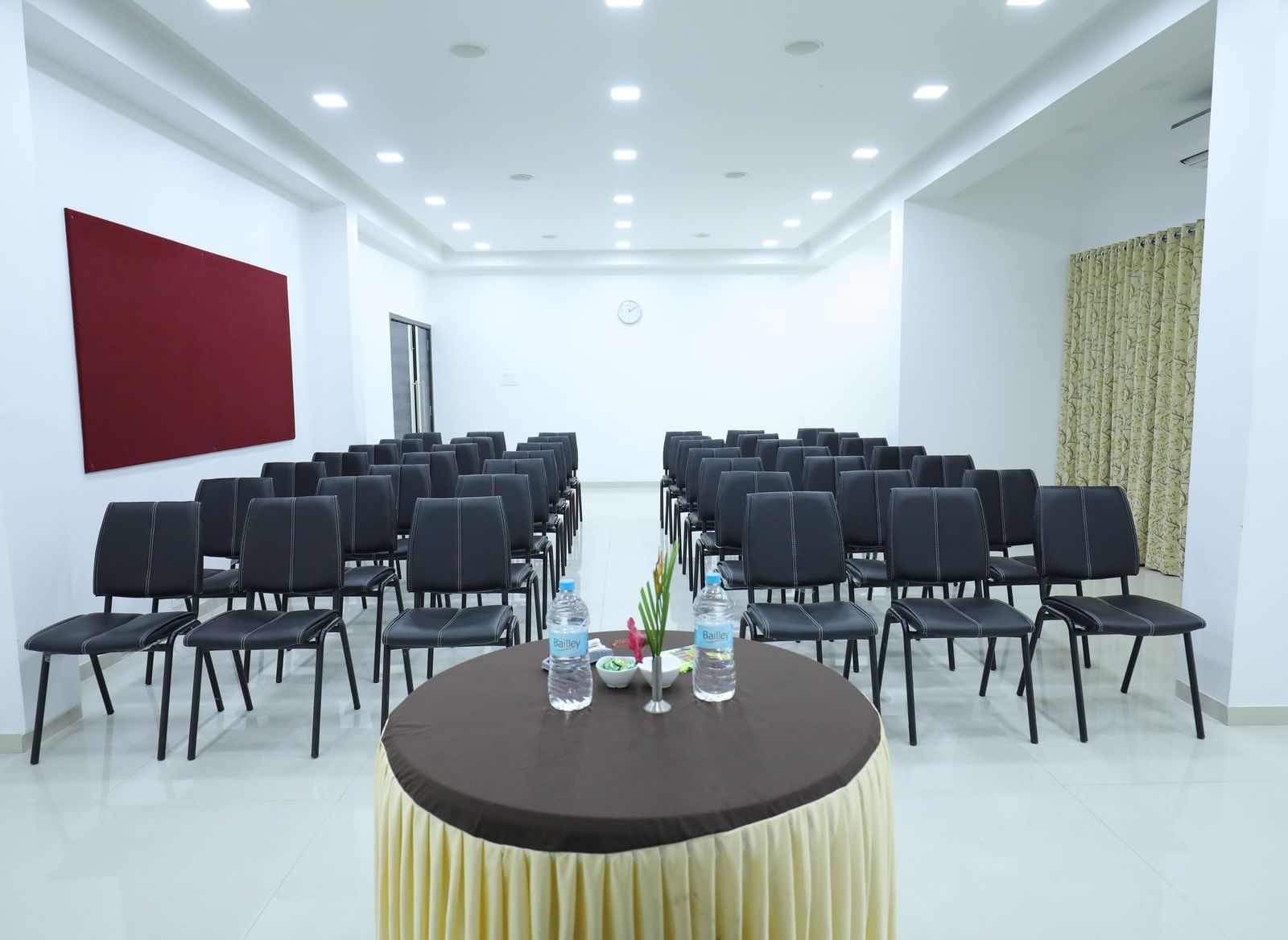 A conference room at Imperial Grande with rows of black chairs facing a small round table in the foreground.