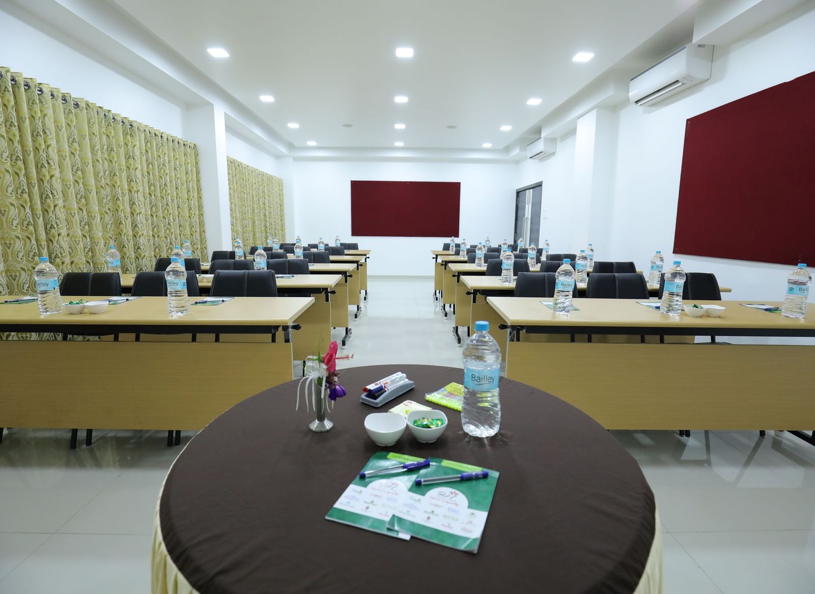 A conference room at Imperial Grande with a classroom style table set up, with a small round table in the foreground.