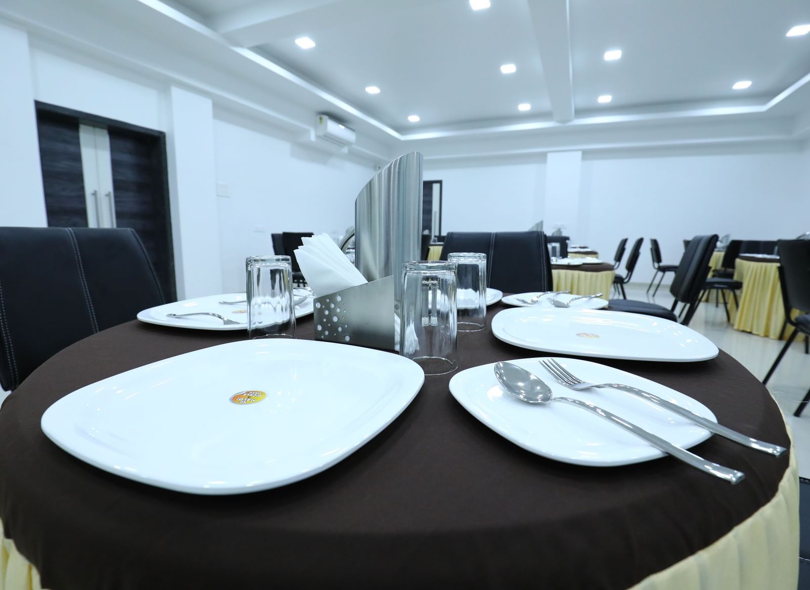 A dining space at Imperial Grande, featuring a round dining table with cutlery set on it.