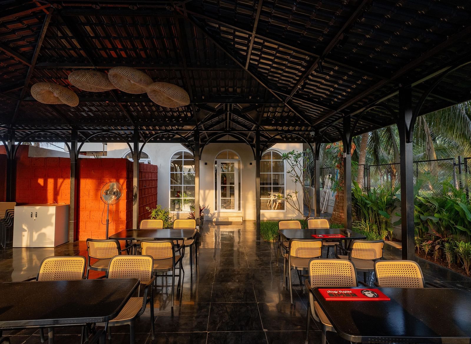A partially enclosed outdoor dining area with a dark, peaked roof at Kssemya.