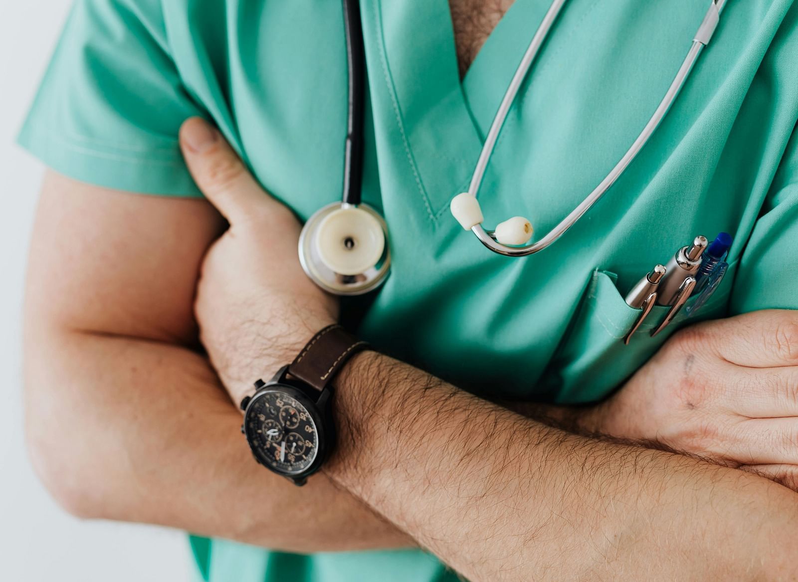 A person wearing a stethoscope around his neck and has their arms crossed.