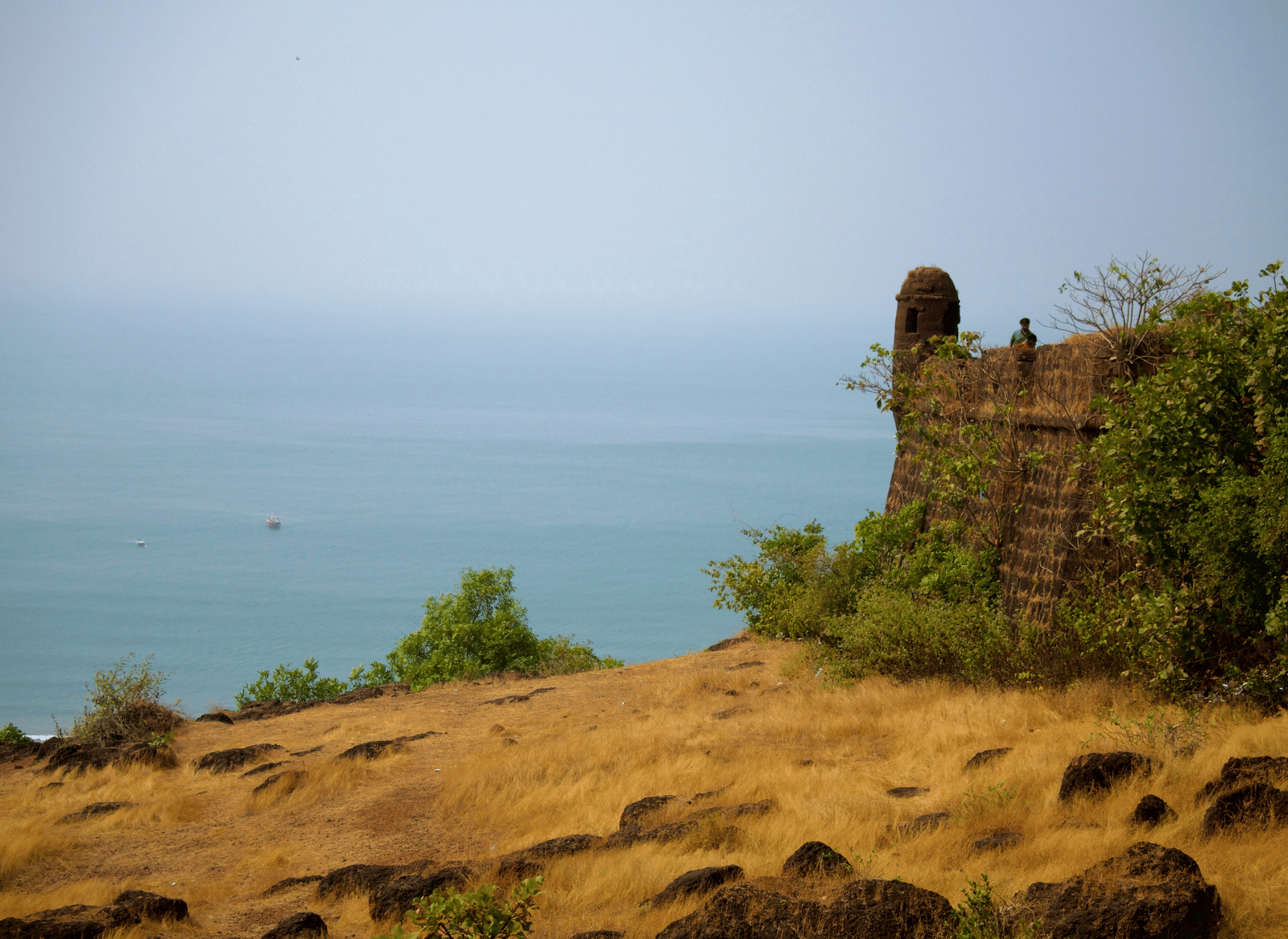 Ruins of Chapora Fort overlooking the Arabian Sea on a hazy day.