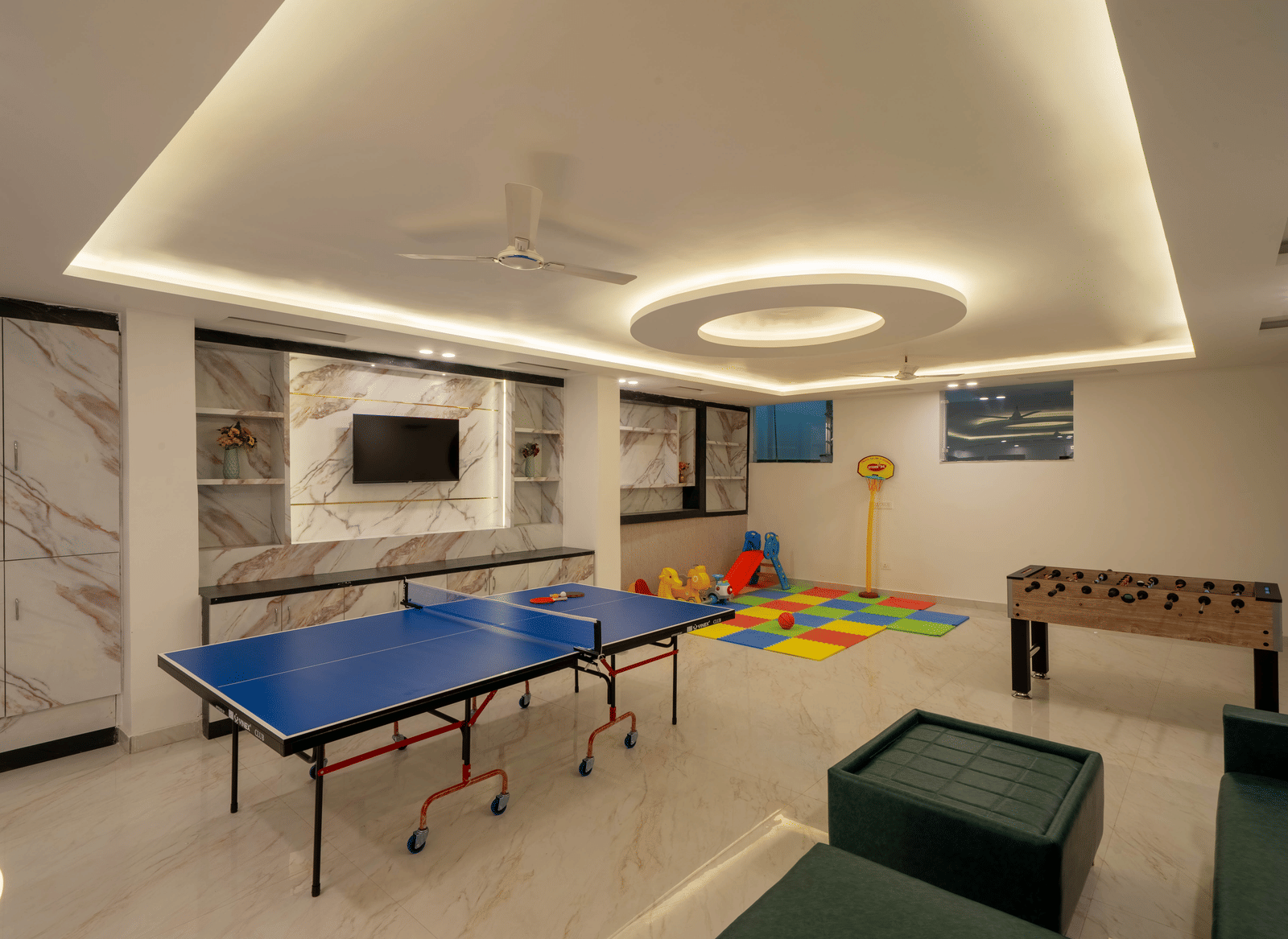 A room for recreation showing a table tennis table, a foosball table, and a wall-mounted television in Perfectstayz Premium Mystic Falls, Rishikesh.