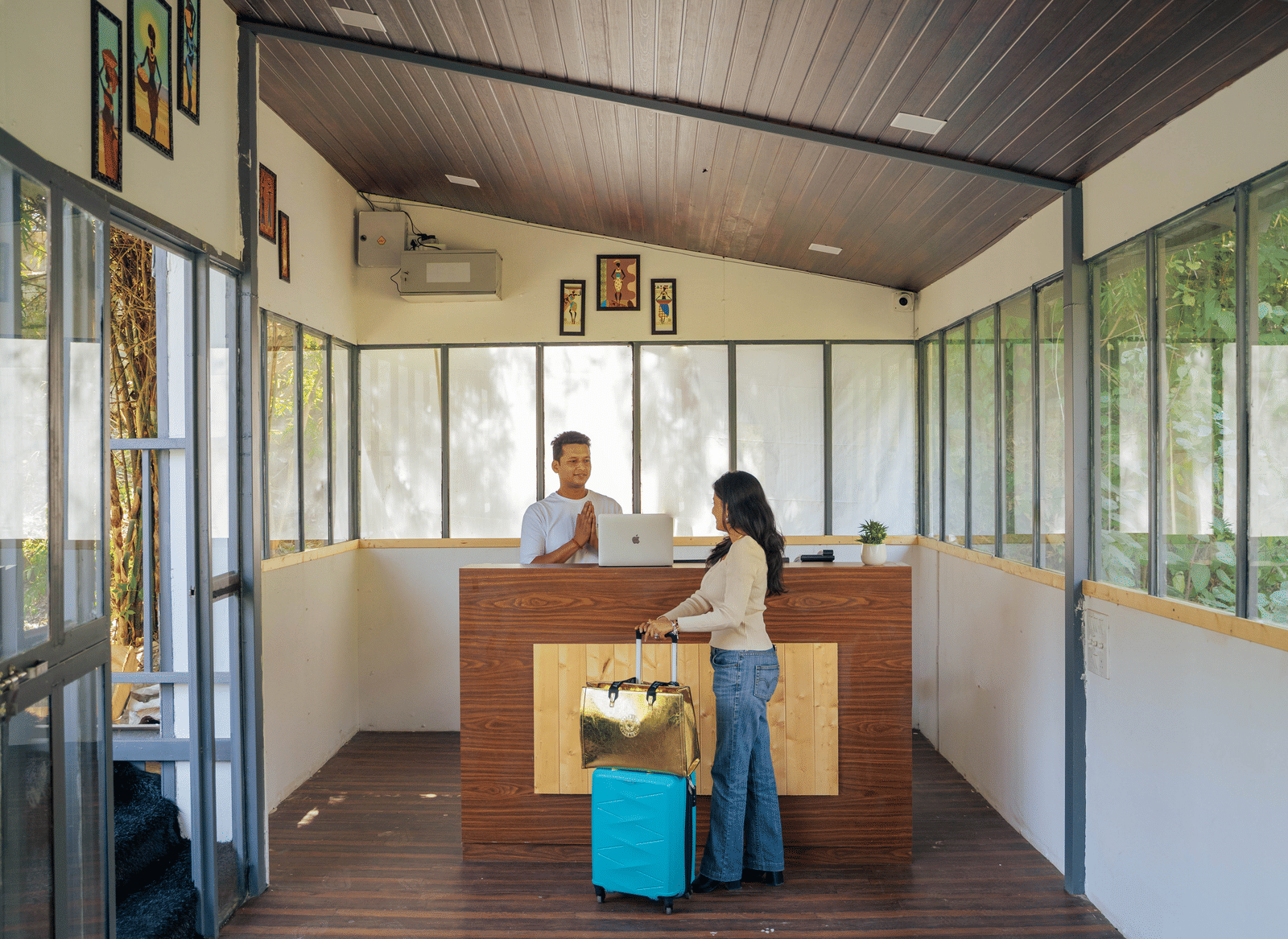 Staff members stand behind a reception desk in a lounge area at Perfect Stayz The Jungle Resort.