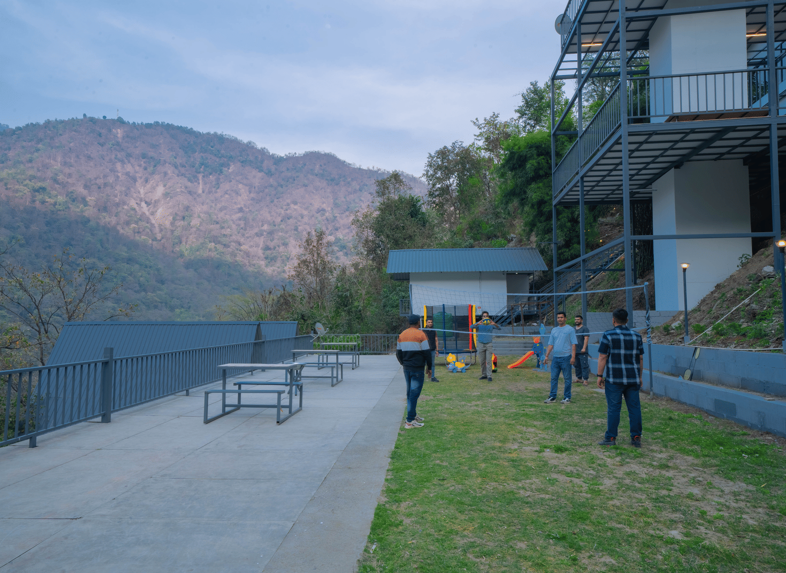 People walk on a lawn near the buildings of Perfect Stayz The Jungle Resort.
