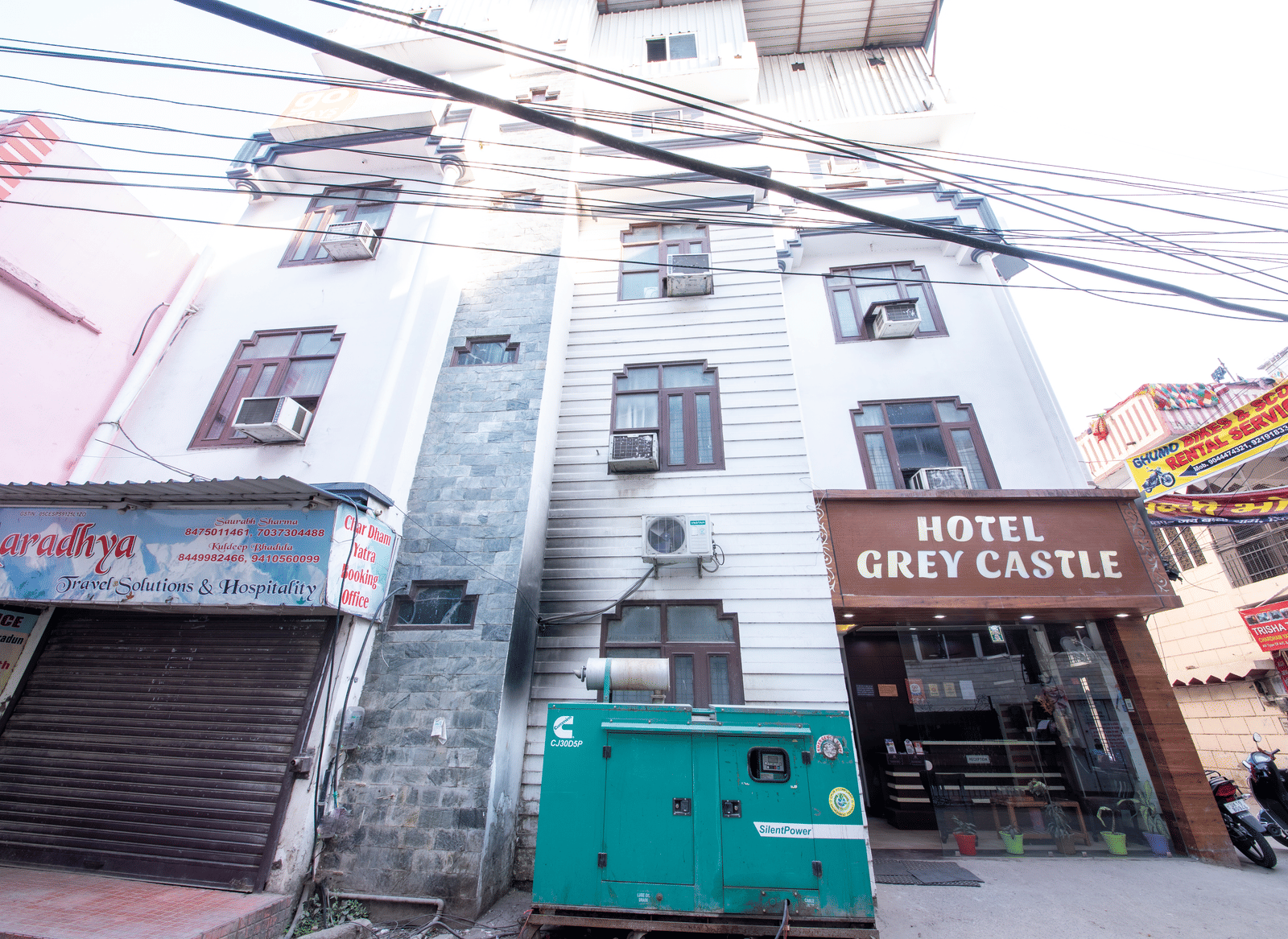 Exterior view of a multi-storey building, with many electrical lines passing through the front - Perfectstayz Value Grey Castle, Haridwar 