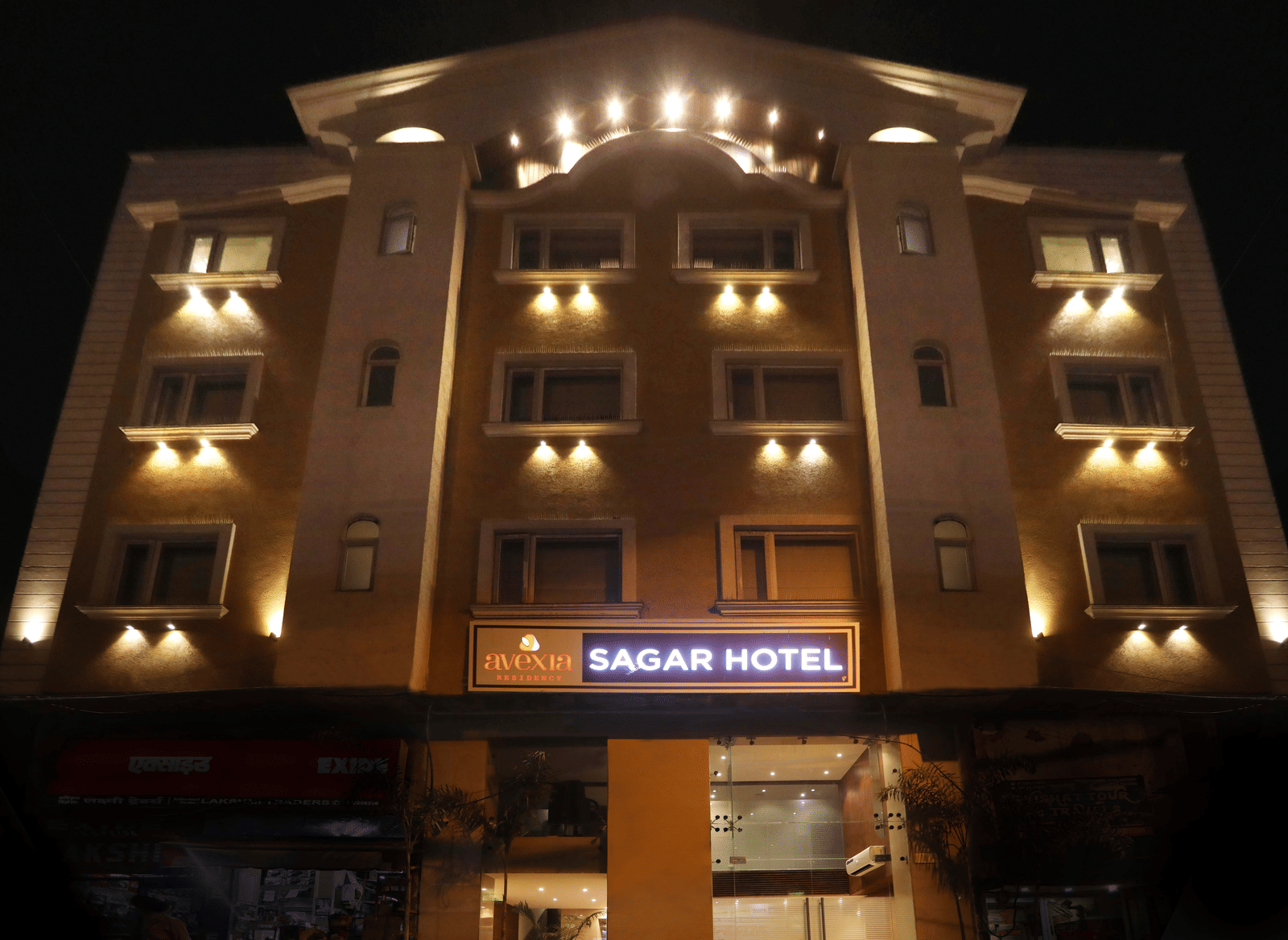 The exterior of a multi-storey hotel building illuminated at night, with a sign that reads 'SAGAR HOTEL' | Perfectstayz Value Sagar