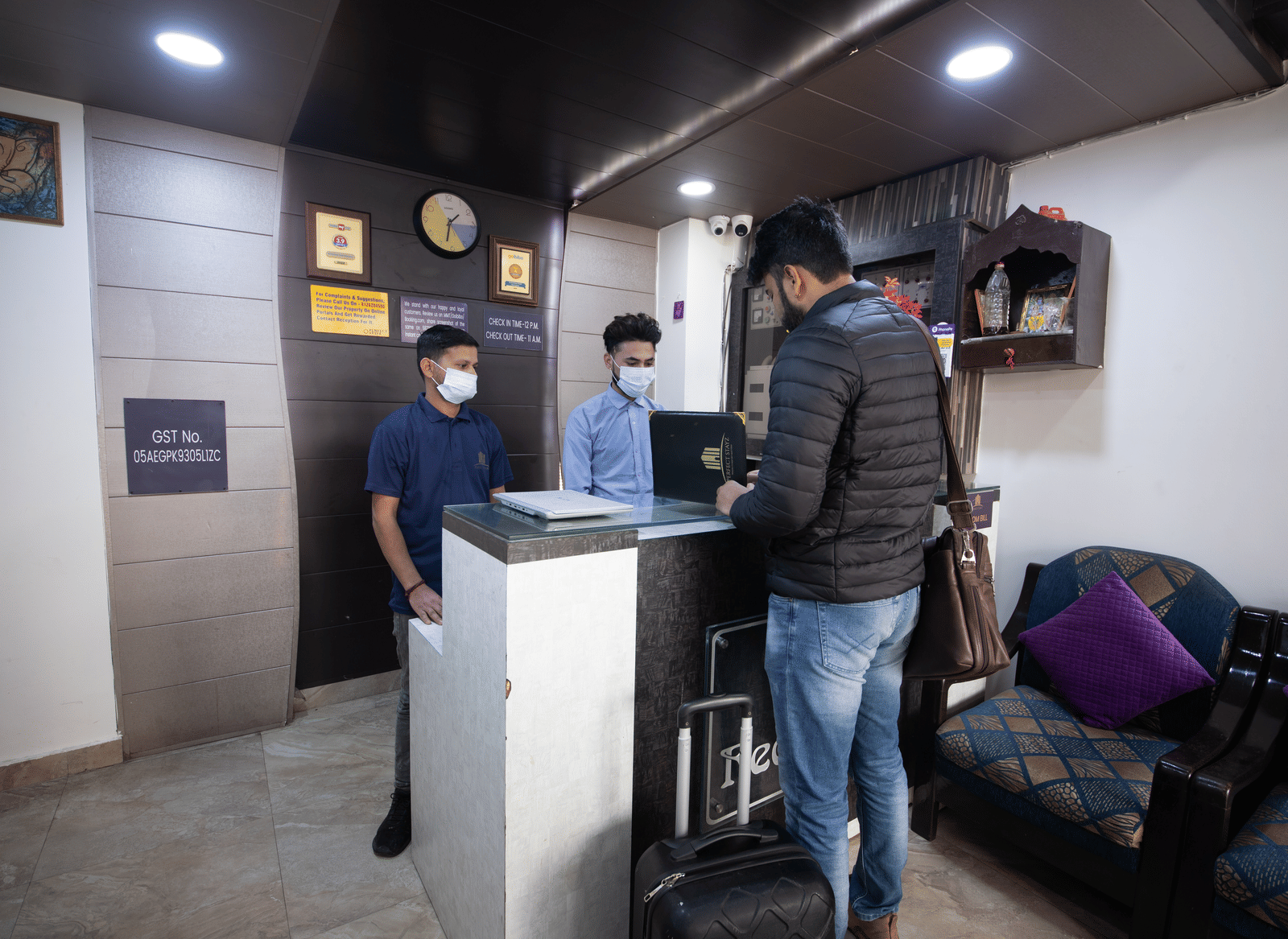 Reception area with staff assisting guests - Perfectstayz Value Umra Grace, Haridwar