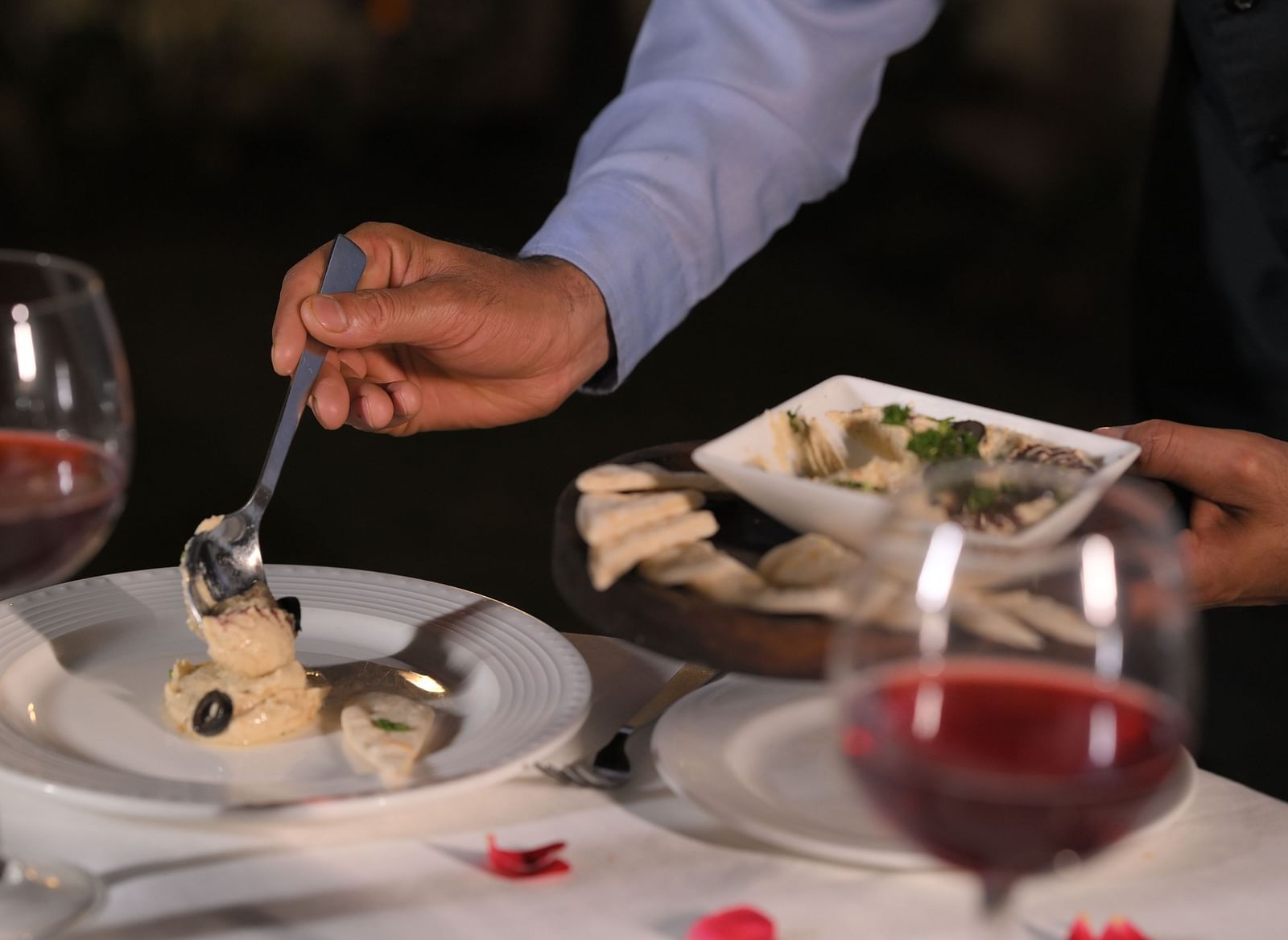 Guest being served a fine dining dish at Royal Comfort Regency with wine, showcasing personalised service and attention to detail.