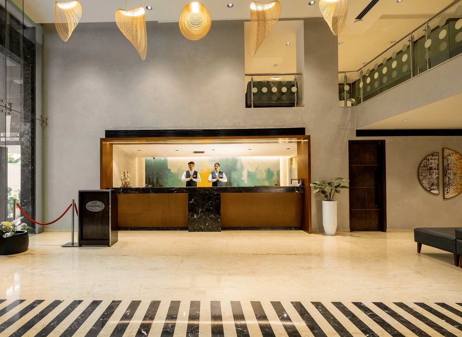 The reception and lobby area of the Citrine Hotel, featuring a large desk and a patterned floor.