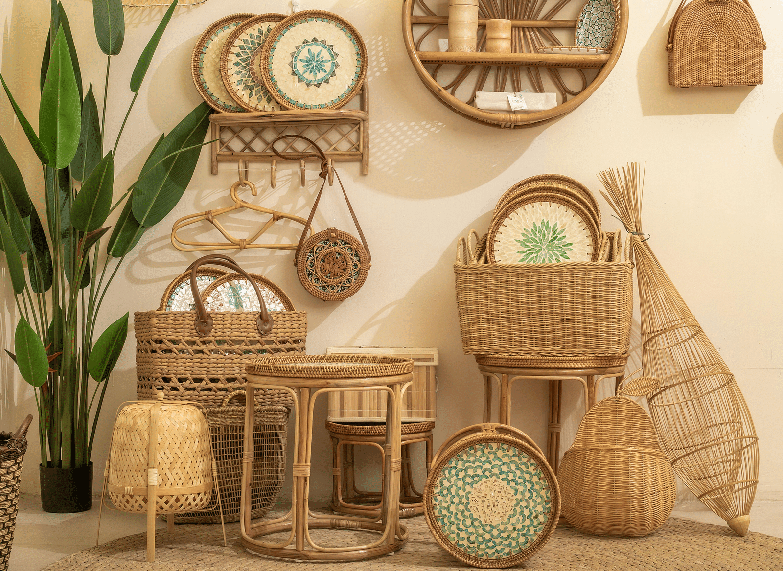 Woven items displayed against a wall, with a potted plant beside them.