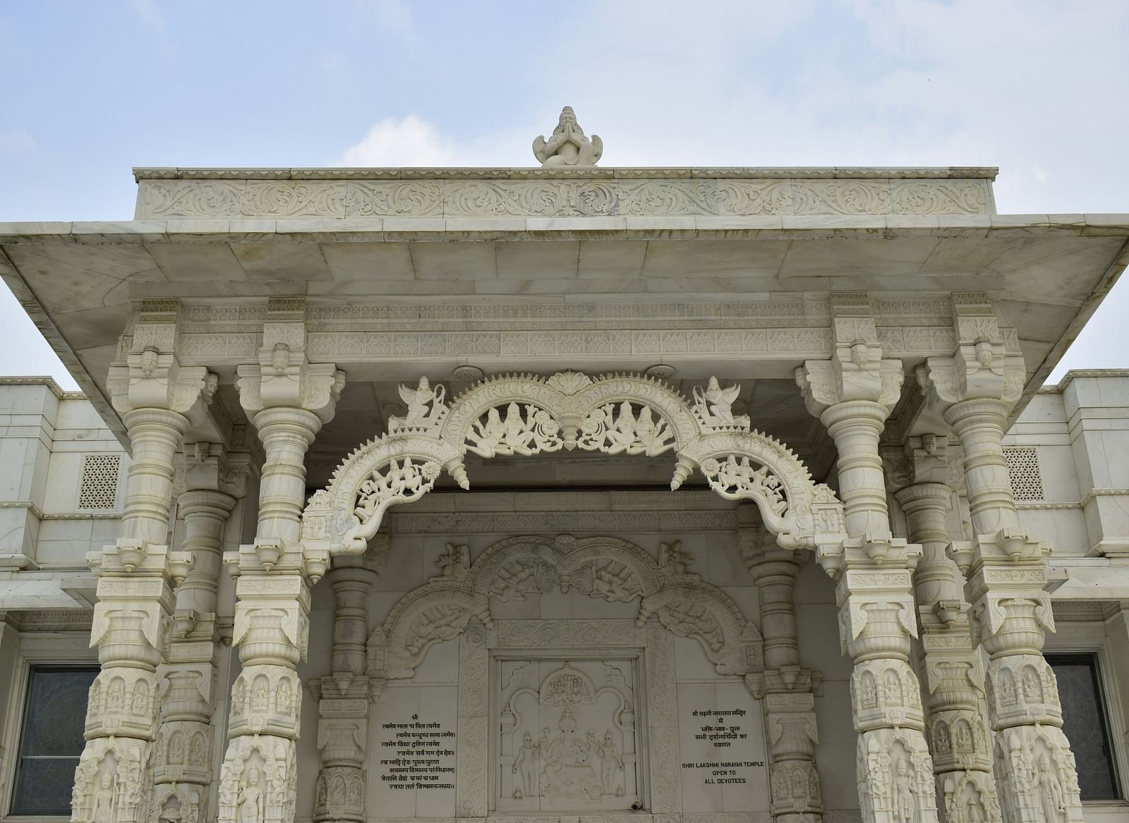 Entrance of Birla Mandir, Jaipur, featuring ornate white marble carvings and pillars.