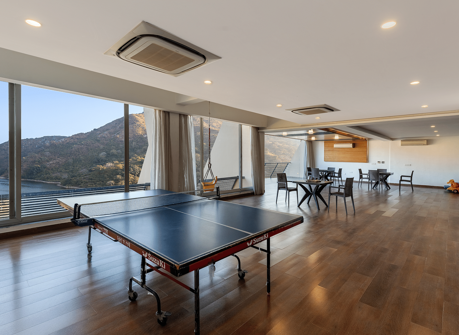 A hall with tennis table and large windows with a view - Via Lakhela Resort & Spa