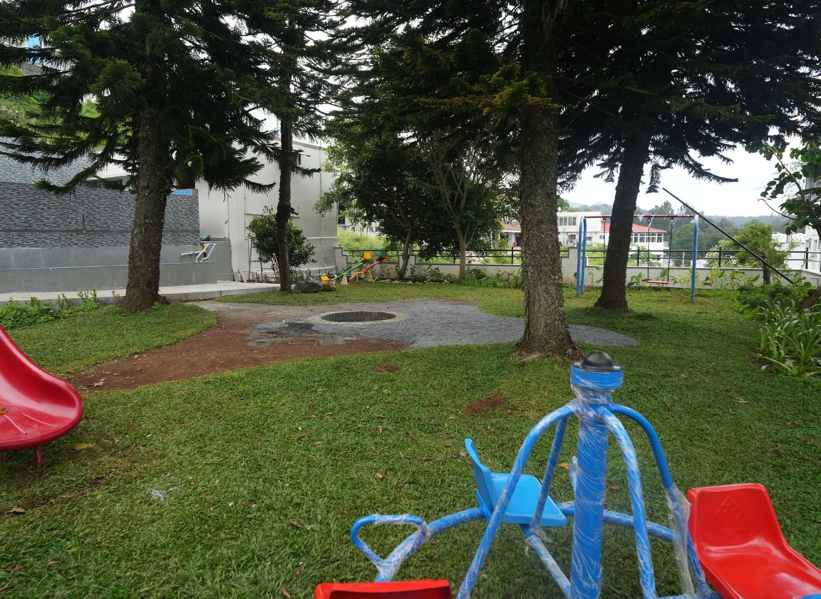 Full-view shot of the outdoor childern's play area along with the bonfire pit at the WOW Naturefull Resorts.