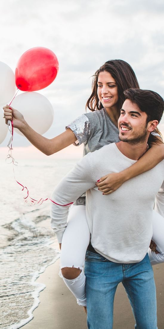 girl-with-balloons-while-her-boyfriend-carries-her-back