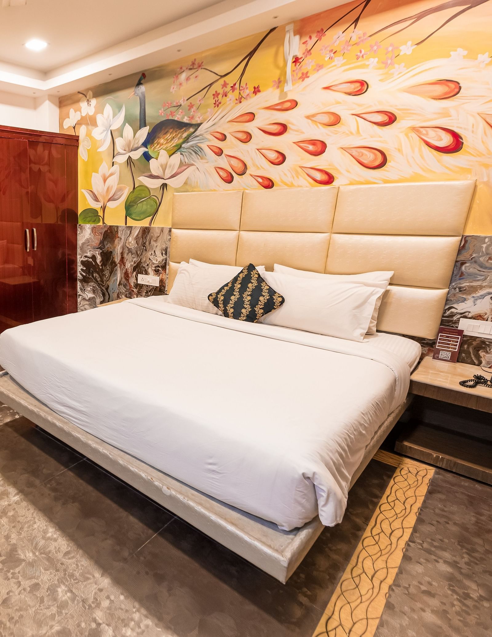 A double bed, chairs and a cupboard at the Deluxe Room at Parakkat Nature Hotel and Resorts Munnar
