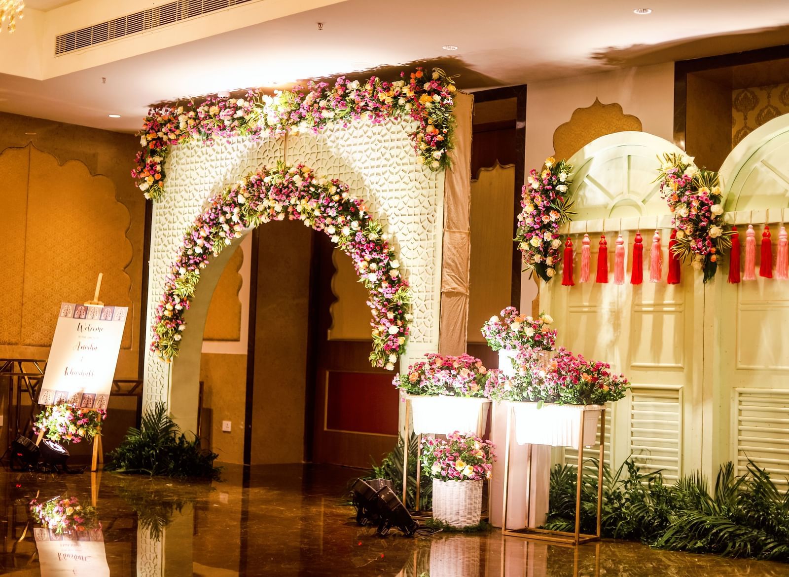The close up shot of the entrance to the ballroom at Kaldan Samudhra Palace featuring potted plants, an arch, a signboard and walls filled with ornamental plants