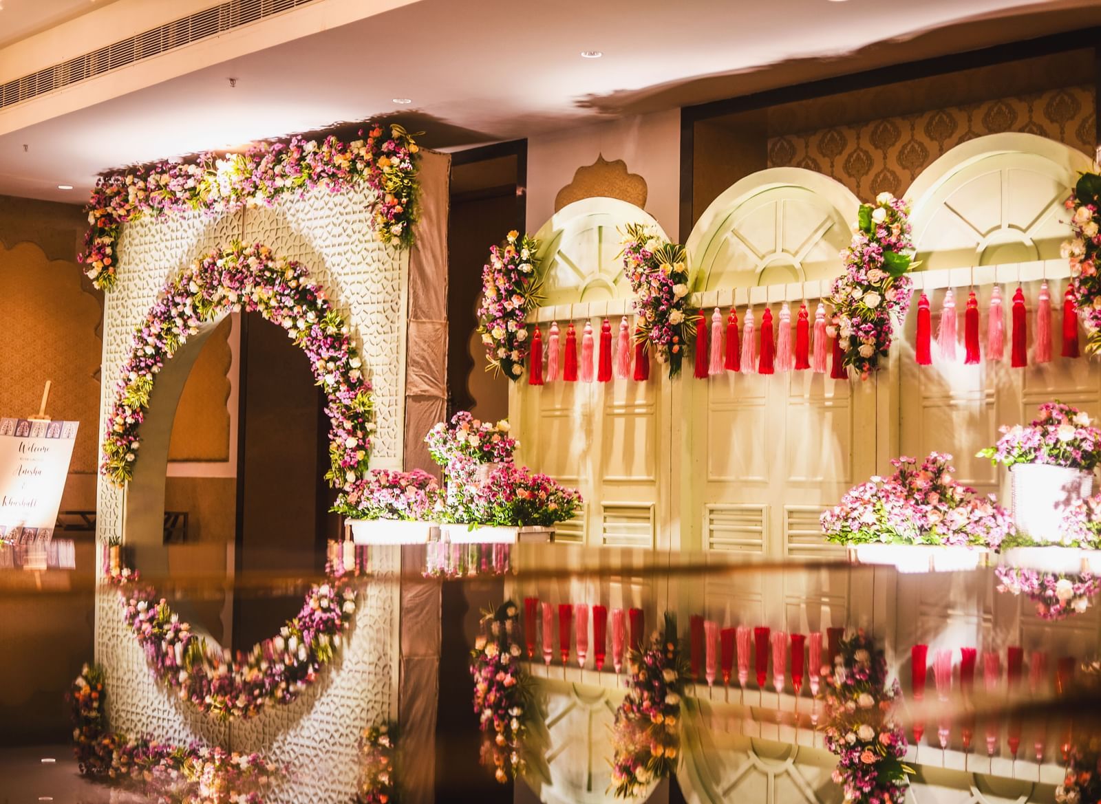 The close up shot of the entrance to the ballroom at Kaldan Samudhra Palace featuring potted plants, an arch, a signboard and walls filled with ornamental plants