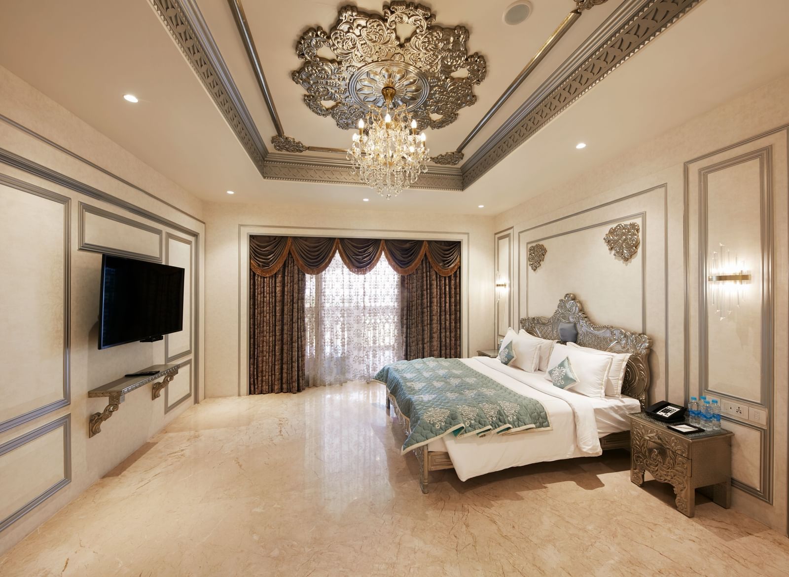 A spacious bedroom in our villa in Mahabalipuram featuring a king-size bed with pastel pillows and an ornate ceiling design – Kaldan Samudra, one of the finest luxury resorts in Mahabalipuram