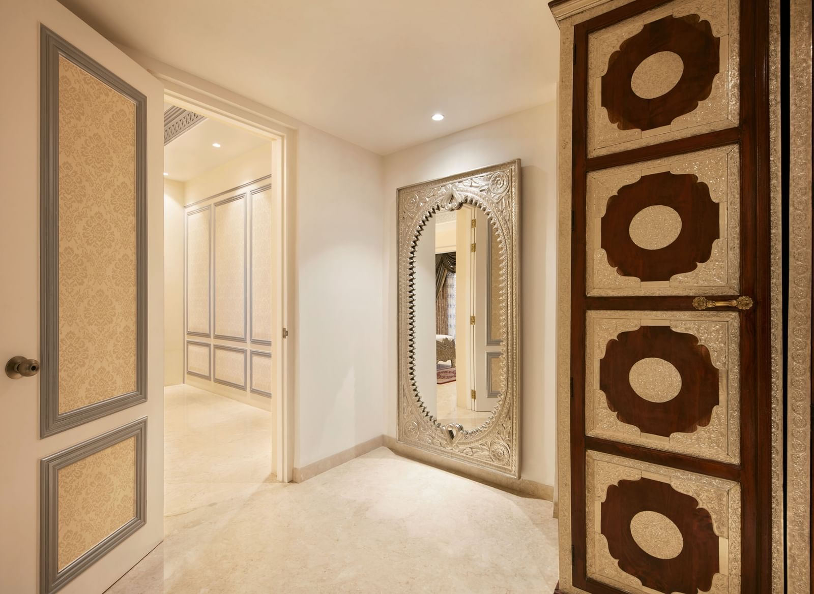 A lavish hallway entrance with carved wooden panels and soft ambient lighting - Kaldan Samudhra