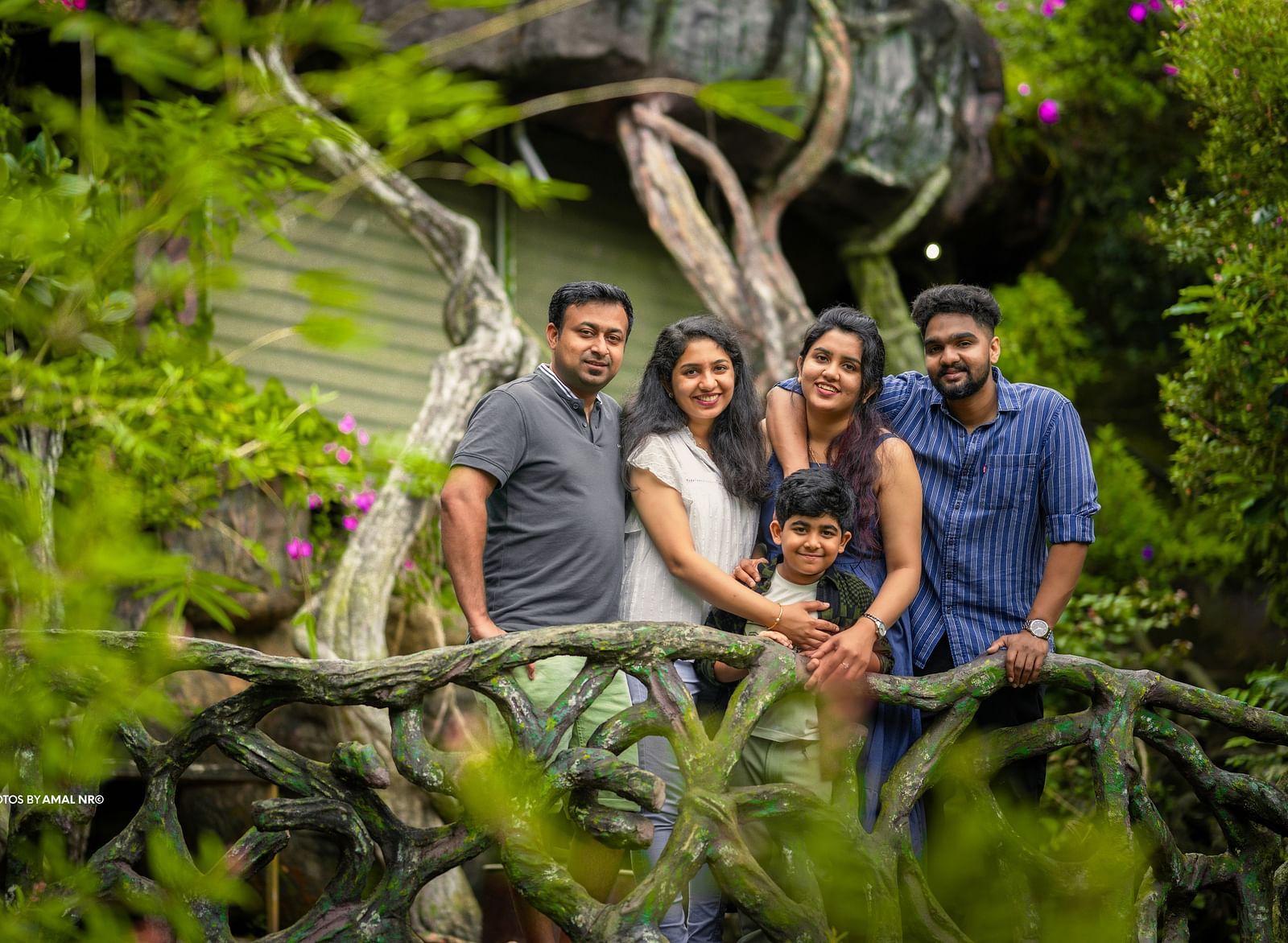 An image of five people posing  near a facade which is surrounded by trees - Parakkat hotel & resorts