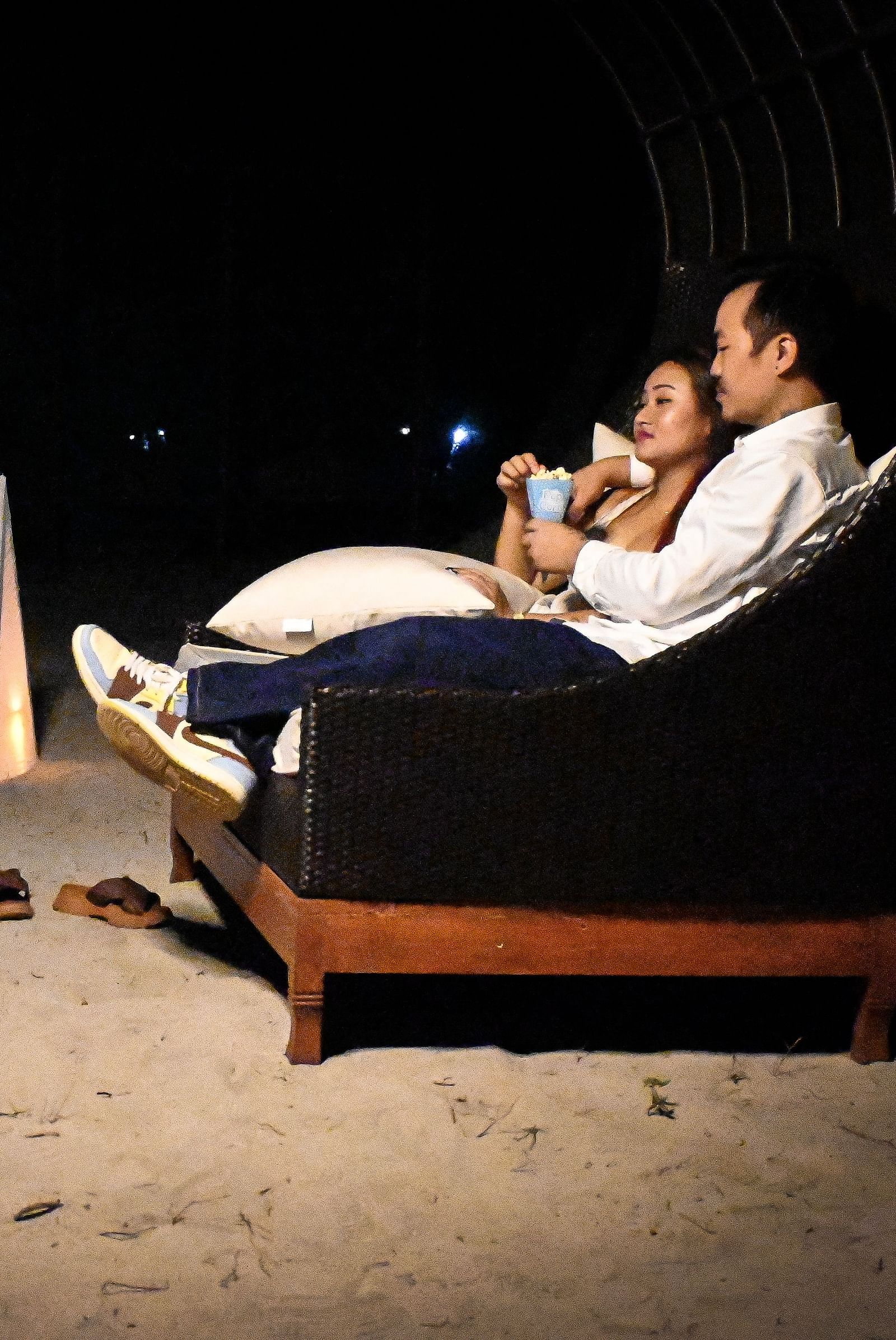 A couple sharing popcorn sitting in a couch setting with wine and roses in front of them - Coral Reef Resort & Spa, Havelock