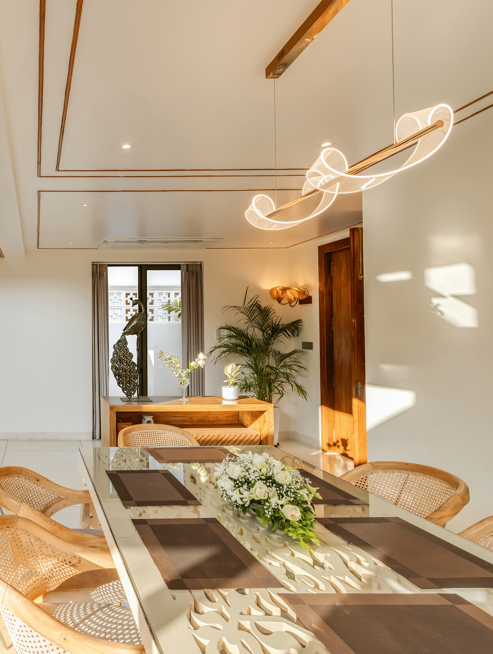 A spacious living room with a double-height ceiling, modern decor, and comfortable seating arranged around a coffee table.
