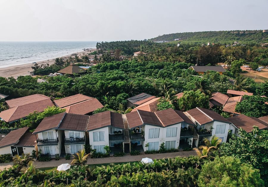 an aerial vie image of the facade of sibaya beach resort, morjim beach that is surrounded by lush tropical greenery
