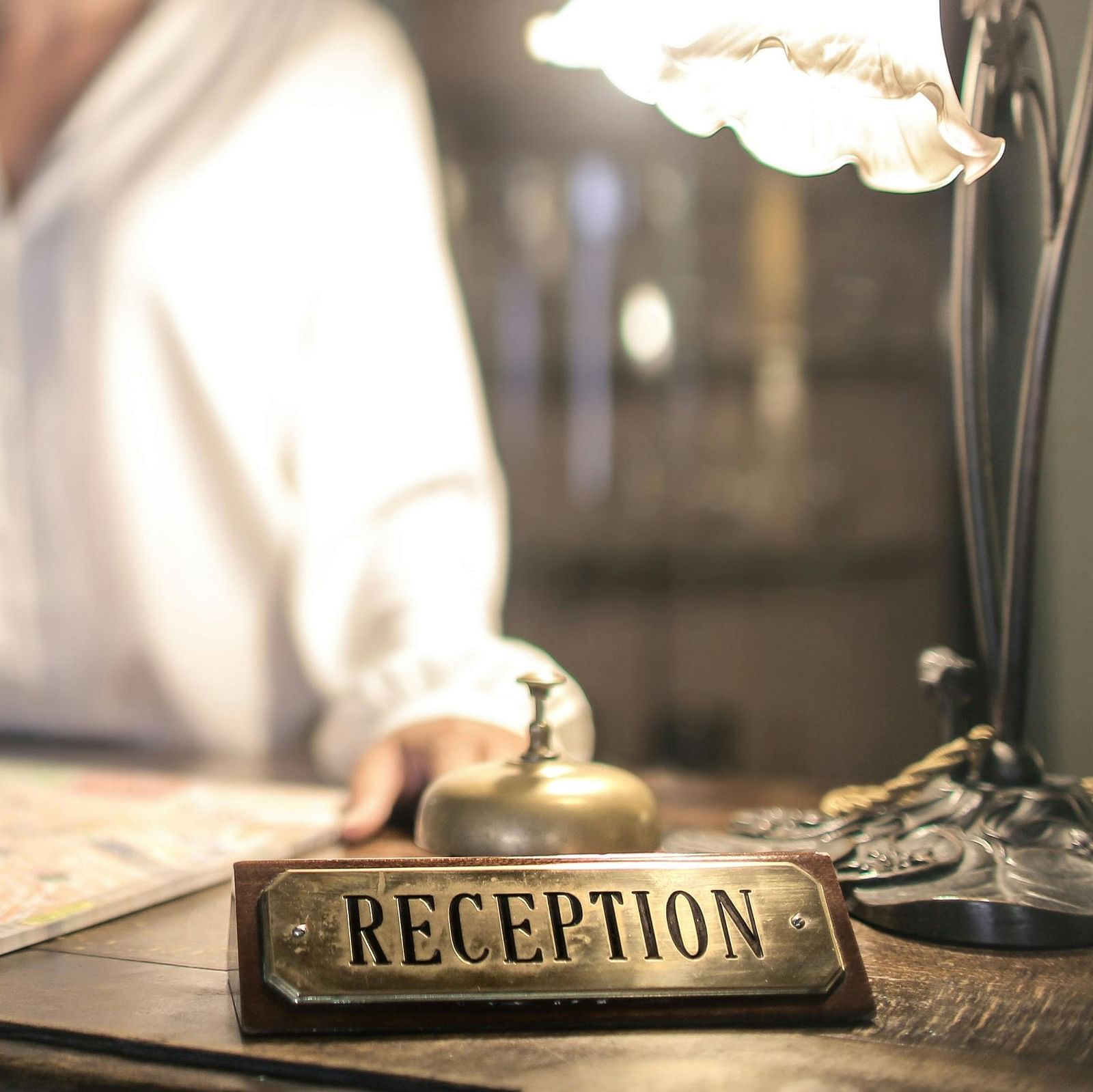 image of a woman standing behind the reception desk with a smile on her face