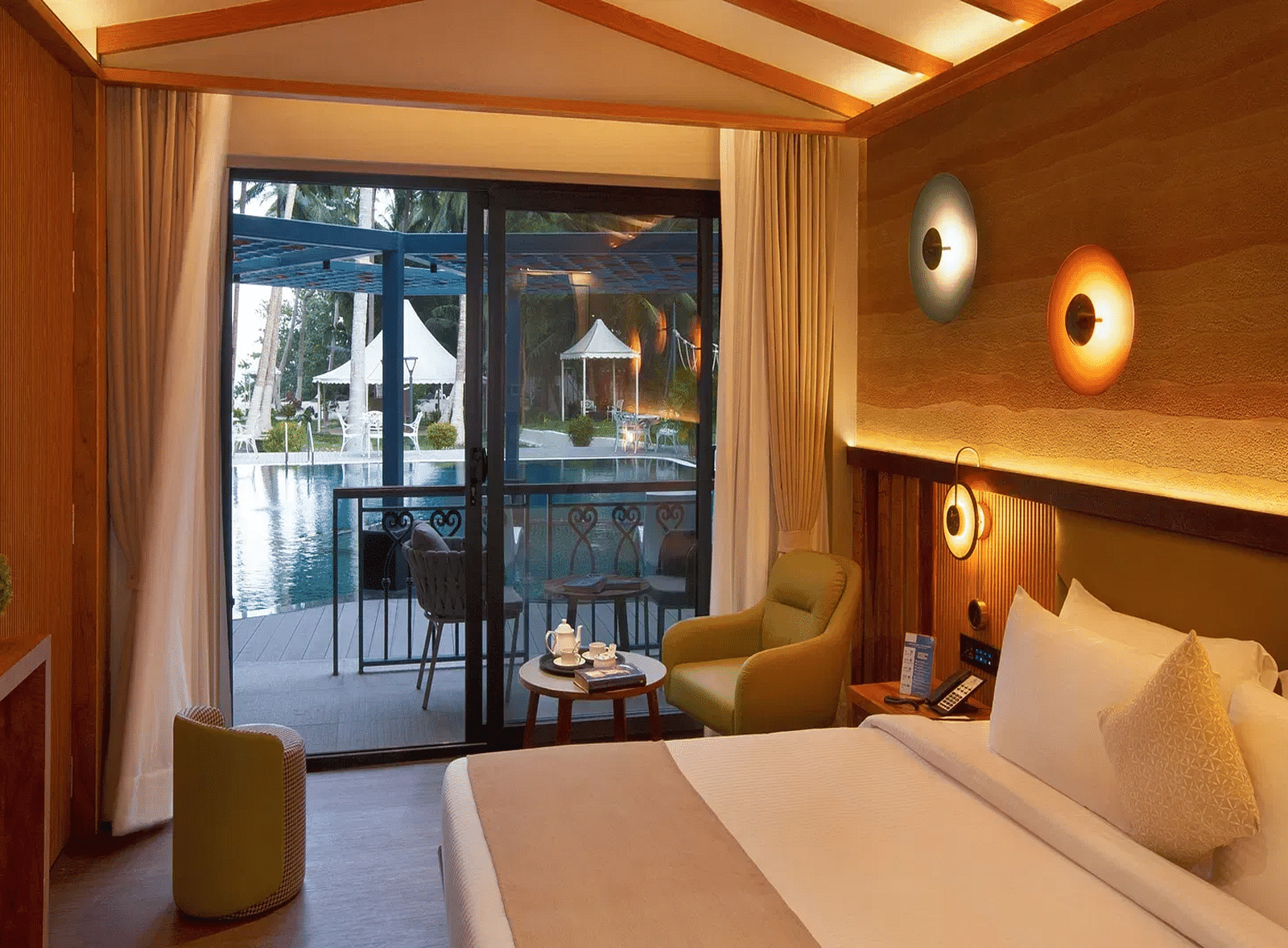 Coral Sapphire at Coral Reef Resort and Spa in Havelock featuring a plush bed and a seating space next to it with the door to the outdoor lounge area beside it  