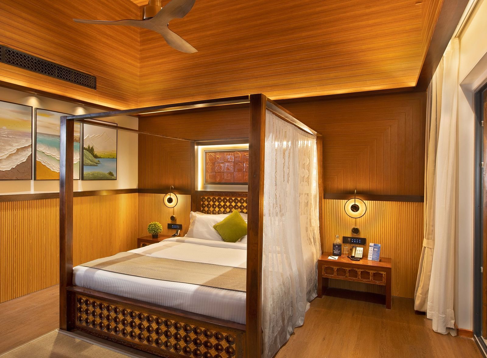 Coral Teal Suite at Coral Reef Resort and Spa in Havelock featuring a plush canopy bed with a nightstand next to it and a lamp over it