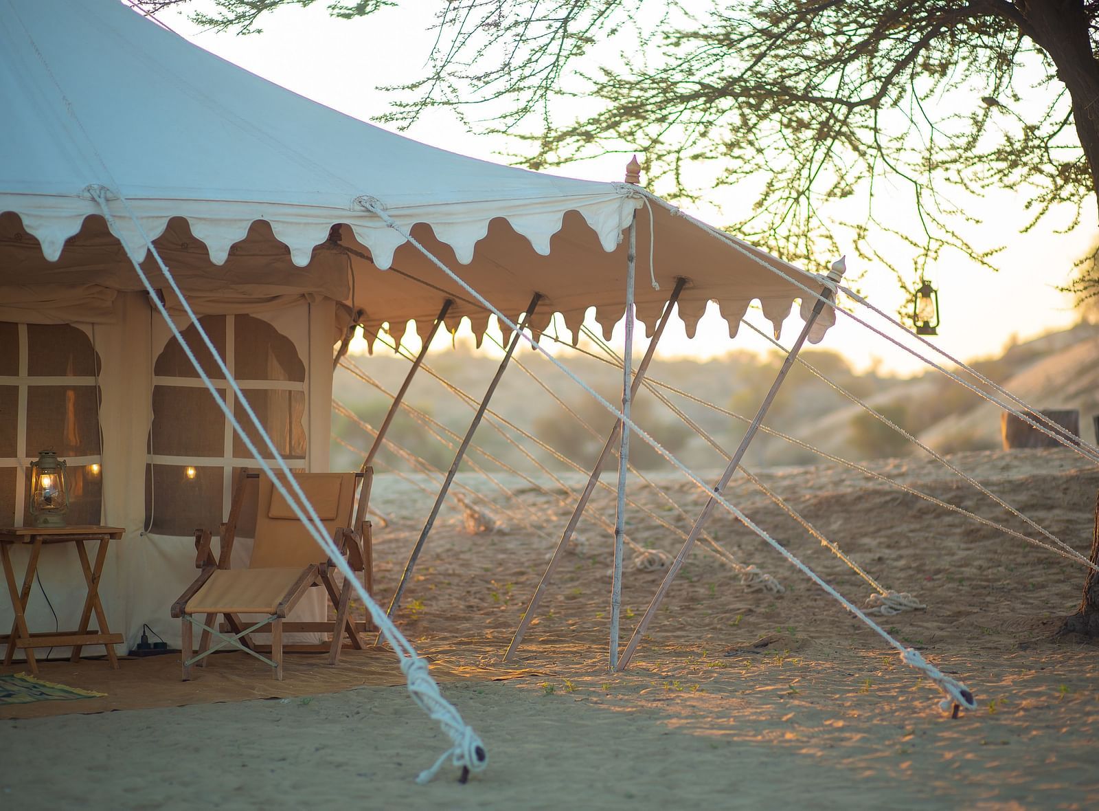 A spacious canvas tent with stylish frills, securely placed in the desert, stands ready for a luxurious escape in the golden light of dusk or dawn. - at Manvar Resort 