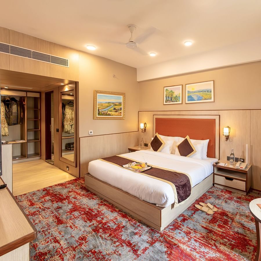 Elegant king bedroom with seating area at The Lalita Grand hotel