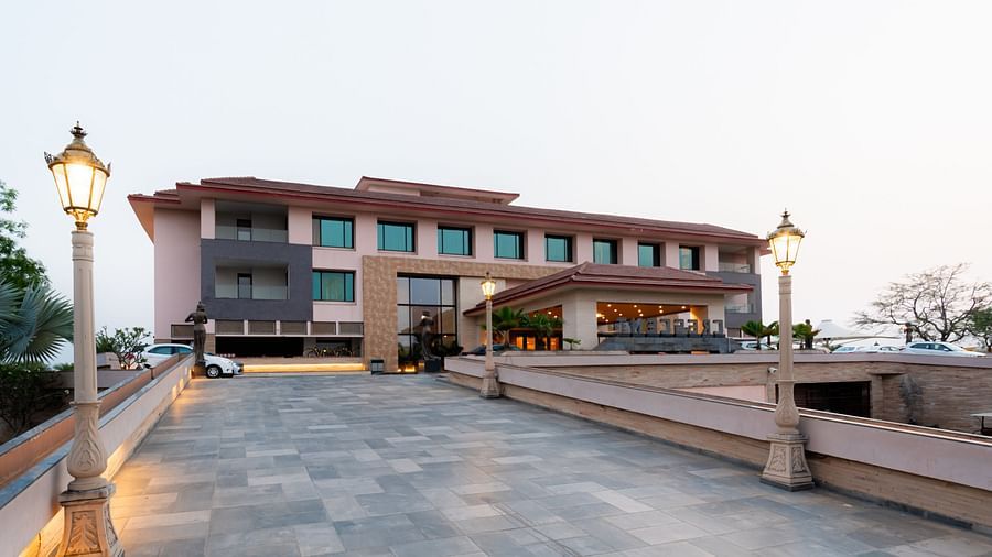 Facade view of Crescent Spa & Resort, Indore, set against a backdrop of a cloudy sky, showcasing its grand architecture
