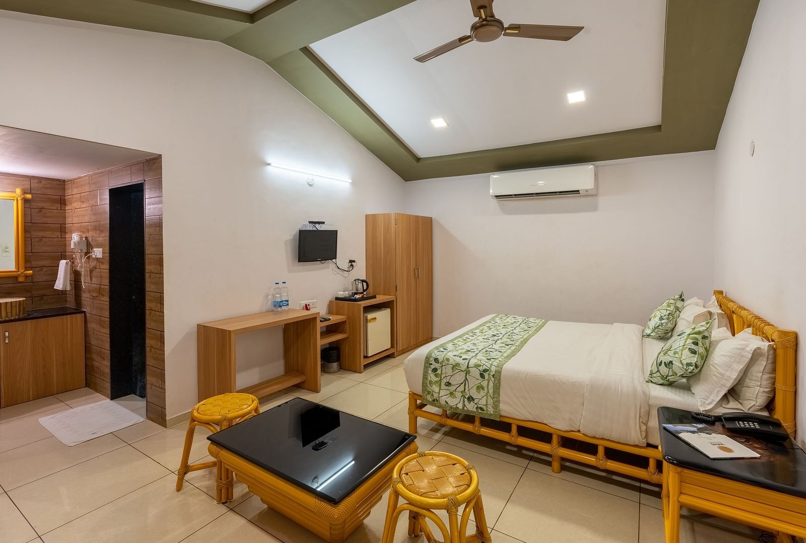 A room with a double bed, seating arrangement and work desk and chair