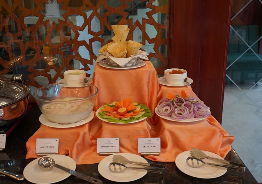 An image of a buffet area where several items like salad, cutlery, plates, fritter, etc are placed like a tower at Five Elements Hotel, Jodhpur