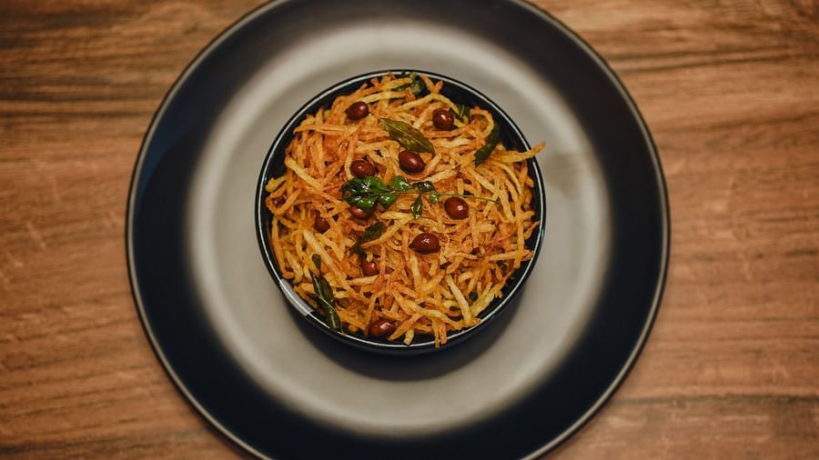 image of a bowl full of an indian snack made of patato topped with fried peanuts - Dip Holidays, Birbhum